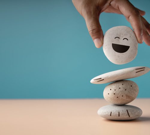 Enjoying Life Concept. Harmony and Positive Mind. Hand Setting White Natural Stone Stack to Balance. Balancing Body, Mind, Soul and Spirit. Mental Health Practice